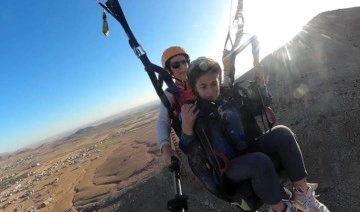 Muğla'dan gelen yamaç paraşütçü çift, Derik'te çocuklarla uçtu